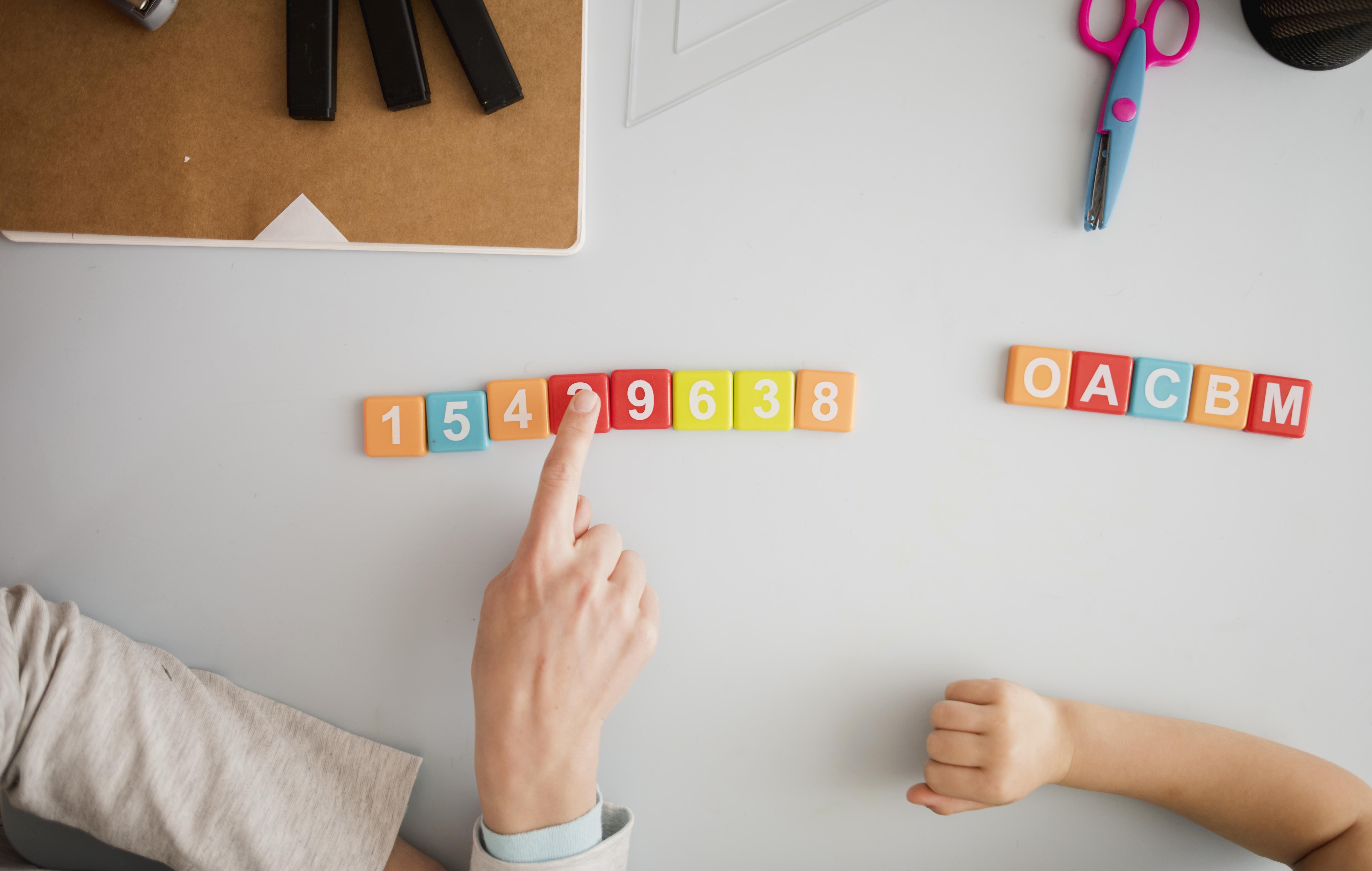 Therapist guiding a child during ABA therapy session to track progress and learning milestones